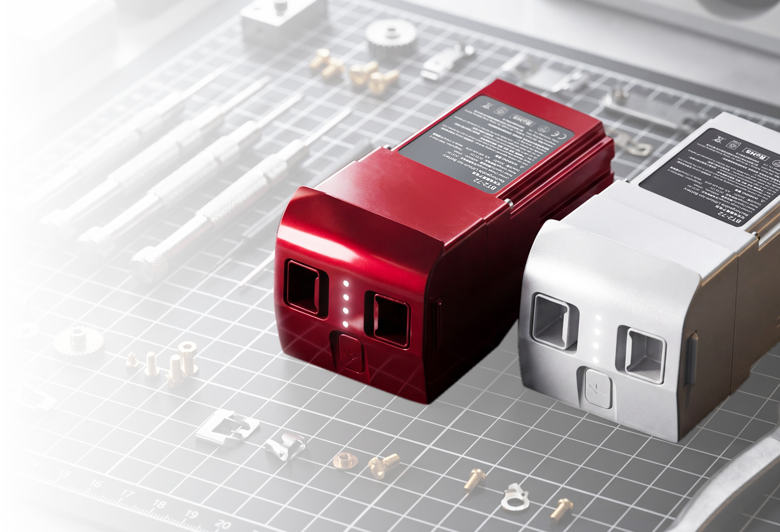 Unitree R1 Battery shown in red and white variants on a workbench